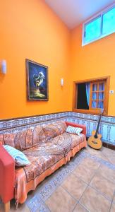 un soggiorno con un divano e una chitarra di Eden GuestHouse a Sardina