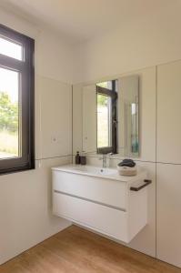 a white bathroom with a sink and a mirror at Casa Candales - Eladia in Cedeira