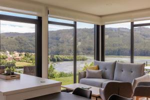a living room with a couch and a large window at Casa Candales - Eladia in Cedeira