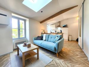 a living room with a blue couch and a table at Les 2 cerfs de Marmande in Marmande