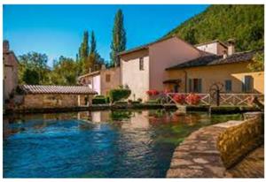 a river in a town with houses and buildings at Locazione Turistica Via Valle Verde 24 in Colfiorito
