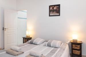 a white bedroom with a bed and two lamps at "Le Zen" by EnjoyNice, central spacious apartment with Airco, beach at 10 min in Nice