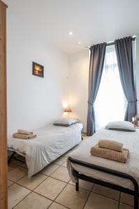 two beds in a room with a window at "Le Zen" by EnjoyNice, central spacious apartment with Airco, beach at 10 min in Nice