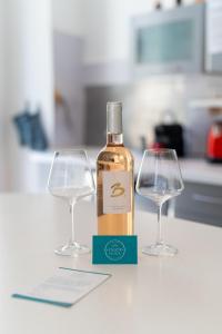 a bottle of wine and two wine glasses on a counter at "Le Zen" by EnjoyNice, central spacious apartment with Airco, beach at 10 min in Nice