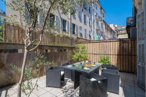 a patio with a table and chairs and a fence at "Le Zen" by EnjoyNice, central spacious apartment with Airco, beach at 10 min in Nice