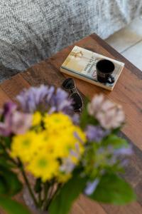 a coffee table with a book and flowers on it at "Le Zen" by EnjoyNice, central spacious apartment with Airco, beach at 10 min in Nice