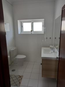 a white bathroom with a sink and a toilet at Buddies Charm Apt - Self Catering in Aveiro +18 photos