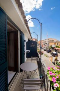 a table and chairs on the balcony of a building at Belmà Aparthotel and Rooms in Marina di Camerota