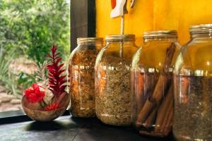 a group of four glass jars filled with spices at Casa Ñi Tayrona in Santa Marta
