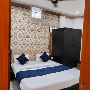 a bedroom with a large bed with blue pillows at RK Hotel & Restaurant in Dewās