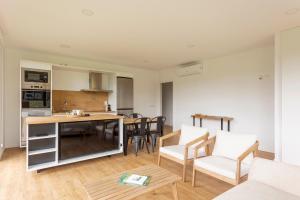 a kitchen and living room with a table and chairs at Casa Candales - Consuelo in Cedeira