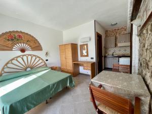 a bedroom with a bed and a table and a kitchen at Villa Raffaela - Appartamenti Lacco Ameno in Lacco Ameno