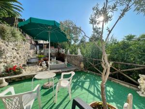 a pool with a table and chairs and an umbrella at Villa Raffaela - Appartamenti Lacco Ameno in Lacco Ameno