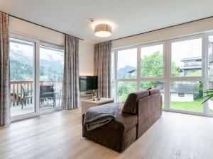 a living room with a couch and large windows at Apart33 Top 1-22 in Haus im Ennstal