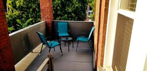 three chairs and a table on a balcony at Bright & Clean 2BR Near Downtown Porch Parking in Pittsburgh