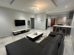 a large living room with a couch and a table at Mountain Drive Apartments in Mbabane