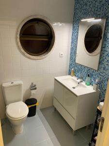 un bagno con un water, un lavandino e uno specchio di Spacious Bedroom In a Modern T3 Apartment a Costa da Caparica