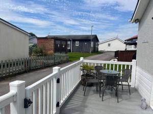 ブリドリントンにあるSeasideEscape-2Br-Sleeps4-Parking-PetsOK-Fireplaceの白いフェンスにテーブルと椅子が備わるバルコニー