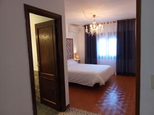 a bedroom with a bed and a chandelier at Casa Al-Hammam in Baños de la Encina