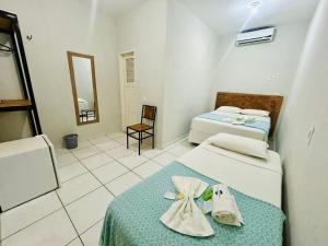een hotelkamer met twee bedden en een spiegel bij Mansomar in Jericoacoara