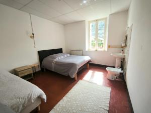 een slaapkamer met een bed, een wastafel en een toilet bij La Maison TILIA in Bessèges