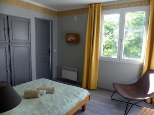a bedroom with a bed and a window and a chair at Gîte de séjour et d'étape l'Escampette in Saint-Jean-du-Bruel