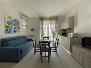 a living room with a blue couch and a table and chairs at Villa Palummera in Forio d'Ischia