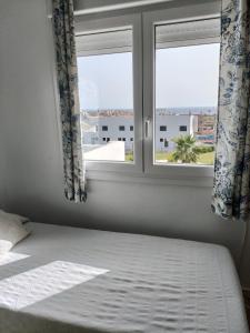 a bed in a room with a window at Casa adosada Rompeolas-Atlanterra in Zahara de los Atunes +27 photos