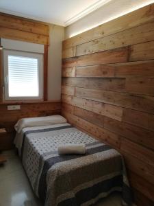 a bedroom with two beds in a wooden wall at Hostal Ochoa in San Adrián +13 photos