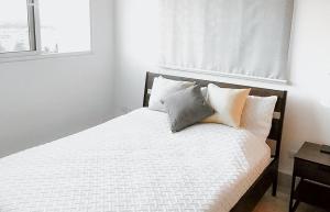 a bedroom with a bed with white sheets and pillows at Luxe Living Spacious Retreat Torre Real Ii in Santiago de los Caballeros +22 photos