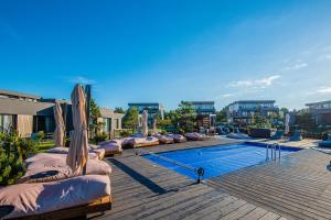 帕兰加SUN HOME的建筑物旁边有躺椅的游泳池