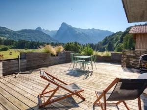 taras z krzesłami i stół z górami w tle w obiekcie Duplex 2 chambres avec grande terrasse, animaux acceptés, à Samoëns - FR-1-642-77 w mieście Samoëns