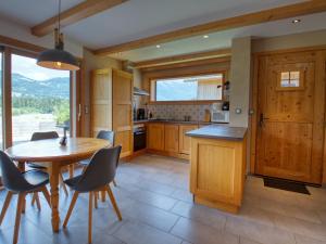kuchnia ze stołem i krzesłami oraz dużym oknem w obiekcie Duplex 2 chambres avec grande terrasse, animaux acceptés, à Samoëns - FR-1-642-77 w mieście Samoëns