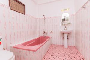 una vasca rosa e un lavandino in bagno di Basundhara Resort Pokhara a Pokhara