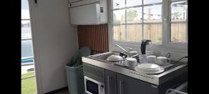 una piccola cucina con un lavandino e una finestra di Lakeside Wevelgem a Wevelgem