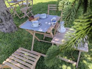 a picnic table with two chairs and a table with cups and saucers at CRALS - Casa do Corgo in Barroselas