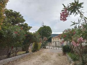 a garden with a fence and flowers and a house at Maison individuelle plein centre avec jardin ,au pied du Mont Ventoux in Malaucène