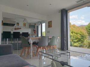 a dining room and living room with a table and chairs at Maison individuelle plein centre avec jardin ,au pied du Mont Ventoux in Malaucène