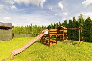 a playground with a slide in the grass at Pensjonat Złoto Bałtyku in Łeba