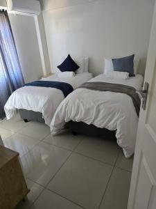 two beds sitting next to each other in a room at Gae La Rona Self Catering Apartment in Gaborone