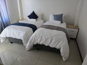 two beds sitting next to each other in a room at Gae La Rona Self Catering Apartment in Gaborone +30 photos