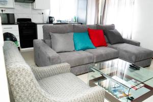 a living room with a couch and two chairs at Gae La Rona Self Catering Apartment in Gaborone