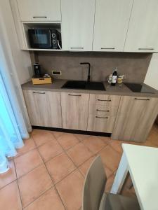 a kitchen with a sink and a microwave at Le perle 2 di Naxos in Giardini Naxos