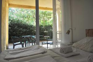 una camera da letto con un letto e vista sul patio di Domaine des Bains a Vals-les-Bains Altre 42 foto