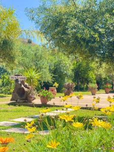 a garden with potted plants and flowers in the grass at Rida Village Ksamil Island in Ksamil
