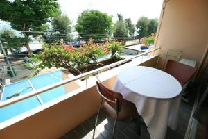 un balcone con tavolo, sedie e piscina di Beachfront Hotel Cha Am a Petchaburi