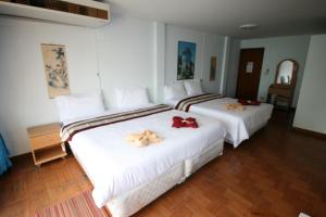 2 letti in camera d'albergo con asciugamani di Beachfront Hotel Cha Am a Petchaburi