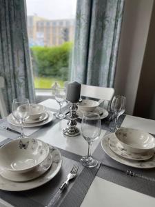 a table with plates and wine glasses on it at 2 Bedrooms Holiday home in Edinburgh near City Center in Edinburgh