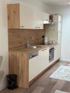 a kitchen with white cabinets and a sink at Luxury Pyramid Apartment Visoko in Visoko