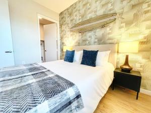 Un dormitorio con una gran cama blanca con almohadas azules. en The Executive Getaway, en San Diego
